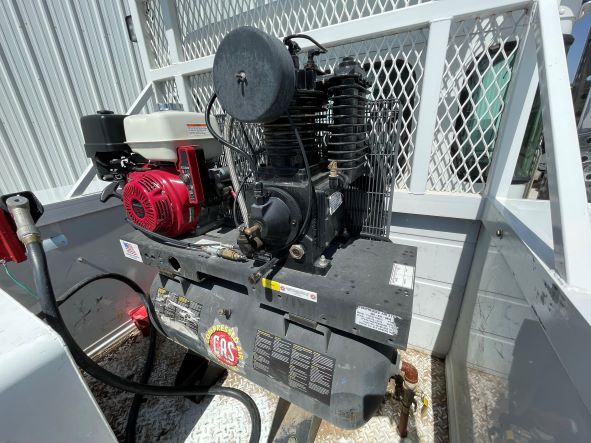 Our service truck with an air compressor mounted in the bed of the truck.